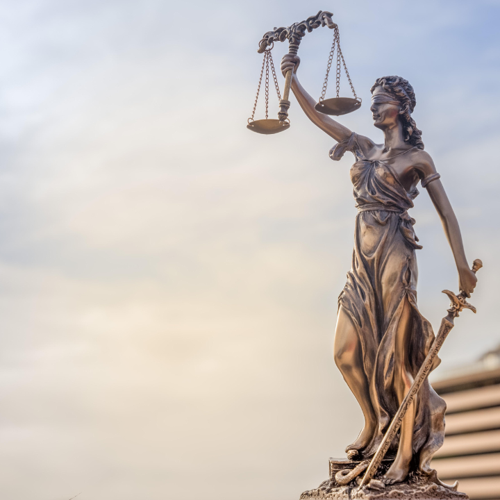 image of lady justice scales against blue skys